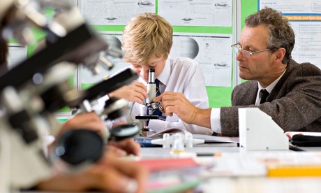 Student and teacher with microscope in science class