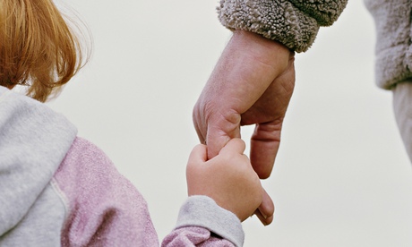 older man holds child's hand