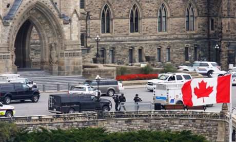 Armed RCMP officers approach Centre Block on Parliament Hill following a shooting incident in Ottawa
