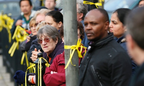 Local people on a yellow ribbon-lined street watch as the hearse carrying the coffin of murdered schoolgirl Alice Gross drives past.