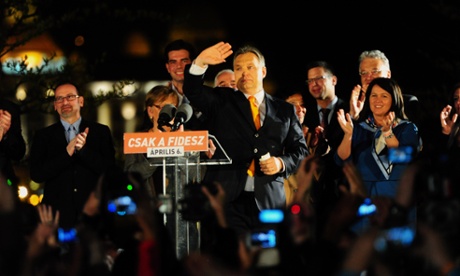 Hungarian Prime Minister Viktor Orban waves to supporters after winning the parliamentary election with members of his FIDESZ party on April 6, 2014