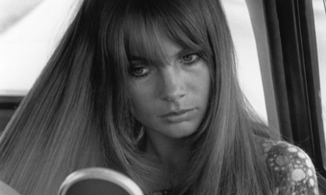 Jean Shrimpton brushing her hair in the back of a car