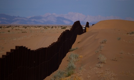 A US border patrol vehicle drives along the Mexico border fence near Yuma, Arizona.