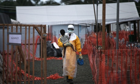 Health worker carries a child suspected of having Ebola