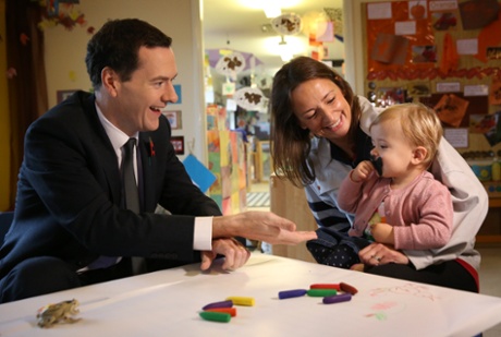 British Chancellor of the Exchequer George Osborne gestures to 18 month old Jessica Woodcock as she sits with her mother Lucy at the Toyota company nursery on October 24, 2014 in Derby, England.