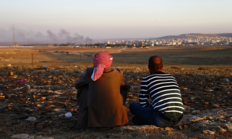 Turkish Kurds watch as smoke from fighting rises over the Syrian border town of Kobani