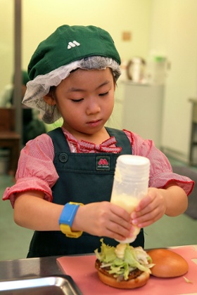 A Japanese child makes a hamburger