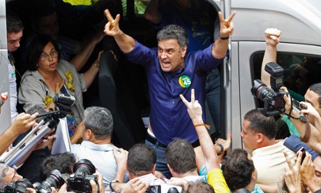 Aécio Neves makes victory signs after voting in the Brazilian presidential election run-off in Belo Horizonte.