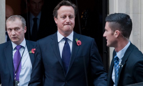 David Cameron, flanked by a protection officer, leaving 10 Downing Street to deliver a statement on the European Union budget in the House of Commons
