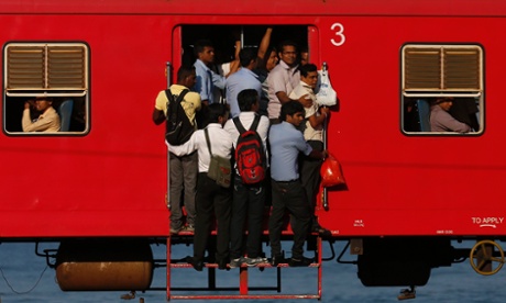 People hang onto a crowded train as they travel to Colombo. Sri Lanka. 