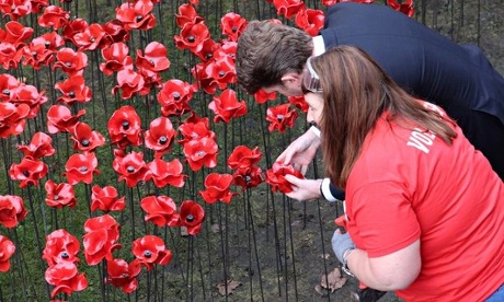 The US ambassador examines a poppy.
