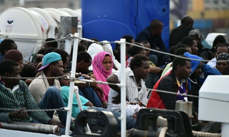 Migrants wait to disembark from the 