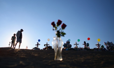 People visit a memorial setup across the street from the Century 16 movie theatre in Aurora.