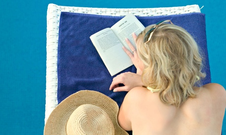 Woman reading book on holiday at pool