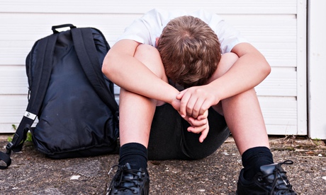 A boy of 10 looking sad and depressed in his school uniform