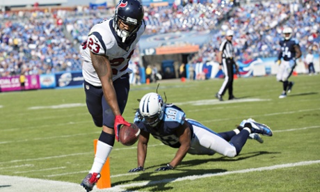 Arian Foster of the Houston Texans scores a touchdown around Michael Griffin of the Tennessee Titans.