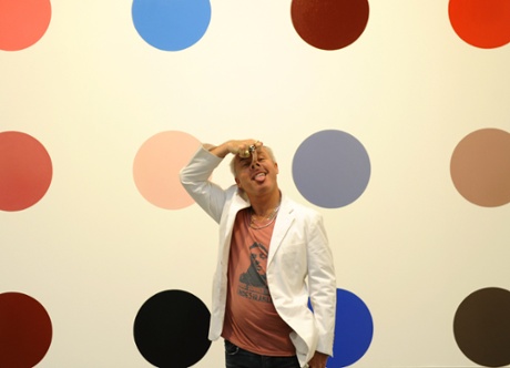 Artist Damien Hirst stands in front of one of 