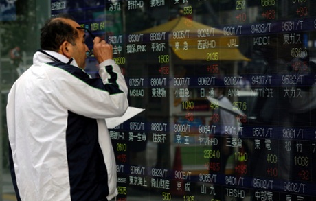 A man looks at an electronic stock board of a securities firm in Tokyo, Friday, Oct. 31, 2014.