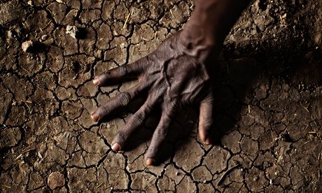 A man places his hand on the parched soil in north-eastern South Sudan, where the UK funded efforts 