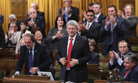 Canada's prime minister, Stephen Harper, stands to vote in favour of a government motion to participate in US-led air strikes against Islamic State militants in Iraq.