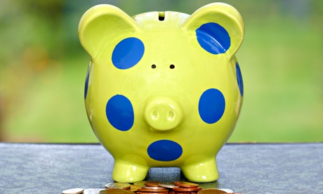 Child's piggy bank with coins piled underneath