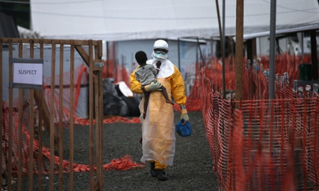 A health worker carries a child suspected of having Ebola into the MSF treatment centre in Paynesville, Liberia.