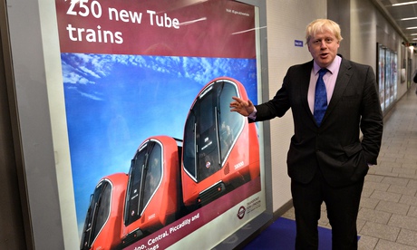 Boris Johnson showing a poster of the New Tube trains
