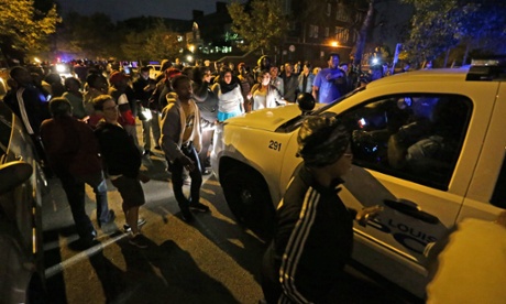 A crowd gathers Wednesday near the scene in south St Louis where a man was fatally shot by an off-duty police officer.
