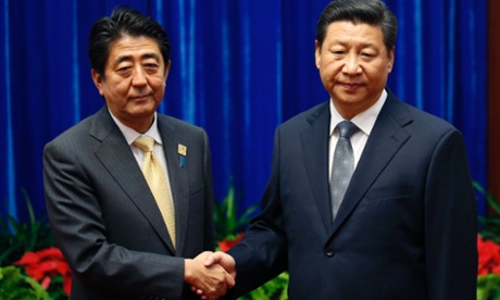 Japan's prime minister Shinzo Abe, left, and China's president Xi Jinping shake hands during their meeting on the sidelines of the Asia-Pacific Economic Cooperation (APEC) summit in Beijing on 10 November.
