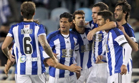 Real Sociedad striker Carlos Vela celebrates with team-mates after scoring against Atlético Madrid.