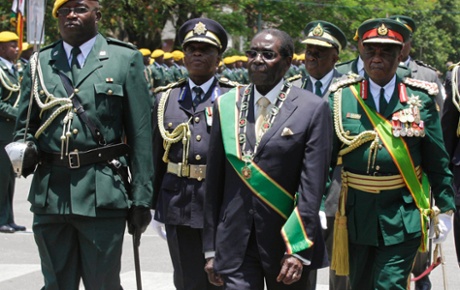Robert Mugabe arrives at the parliament in Harare flanked by guards.
