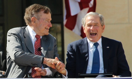 Father and son, and former US presidents, George HW Bush, left and George W Bush shake hands.