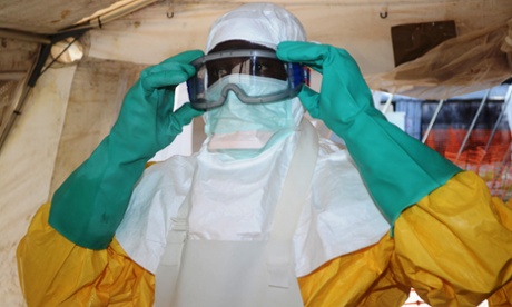 A medical worker dons protective gear in the isolation ward of the Donka hospital in Conakry