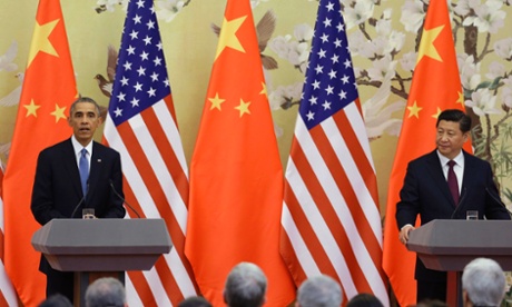 U.S. President Barack Obama (L) speaks to the media in front of U.S. and Chinese national flags during a joint news conference with China's President Xi Jinping (R) at the Great Hall of the People in Beijing November 12, 2014.