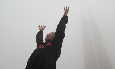 An old man exercises at a smog-shrouded square in Tangshan, China.