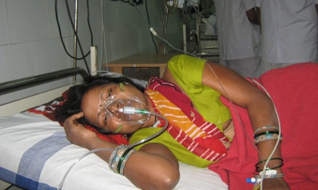 A woman receives treatment on a hospital bed.