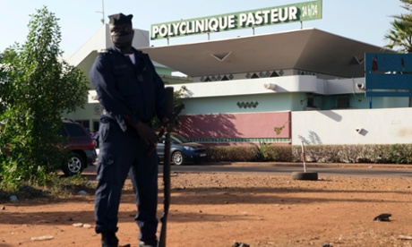 A police officer stands guard outside the quarantined Pasteur Clinic in Bamako where Mali's second case of Ebola was confirmed.