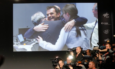 Celebrating scientists in the main control room appear on a video screen at the European Space Agency in Darmstadt, Germany, after the first unmanned spacecraft Philae landed on a comet called 67P/Churyumov-Gerasimenko, on 12 November 2014.