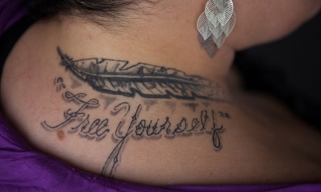 Erica, 33, a sex trafficking survivor, shows a tattoo in her neck that reads 