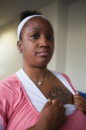 Tonetta, a human trafficking survivor in Columbus, Ohio, poses in the hallways of CATCH court, a program she attends every Thursday. CATCH (Changing Actions to Change Habits) is an innovative, voluntary, two-year program designed to rescue and restore those trapped in the sex trade through intensive probation and rehabilitation services. Here Tonetta shows a gang insignia tattoo that she was given when she was sexually trafficked. Tonetta has applied to a Survivors Ink scholarship to get the tattoo removed or covered with at work.