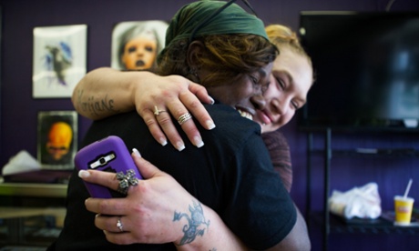 Jennifer Kempton, 32, and Ruthie, 53, hug in a tattoo parlour in Lancaster, Ohio.  Ruthie just had a trafficking scar covered up with a new tattoo thanks to a Survivors Ink scholarship offered by Kempton.