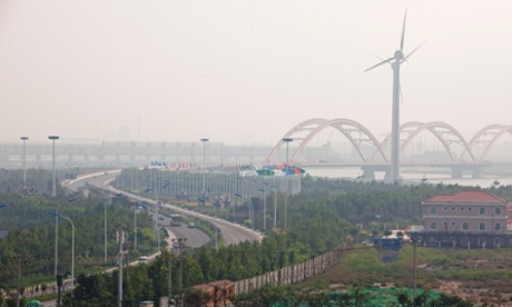 Wind turbines stand at the entrance to the Sino-Singapore Tianjin Eco-city in the Binhai New Area of Tianjin.