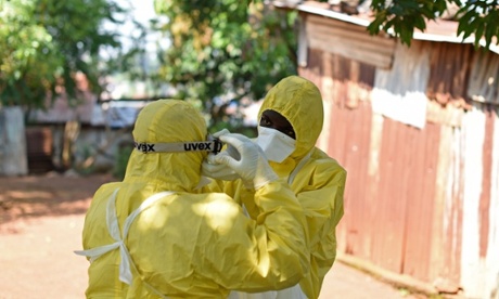 Sierra Leone health workers remove a corpse from a house in Freetown