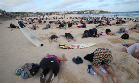As world leaders arrive at the G20 Summit in Brisbane, more than 400 people buried their heads in the sand at Bondi Beach in Sydney.