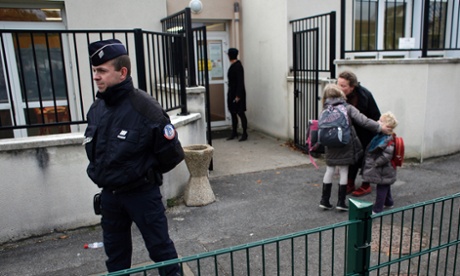 Police officers stand next to a school in Montevrain on Friday morning.