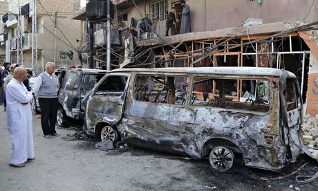 Iraqis inspect the site of a car bomb in Baghdad