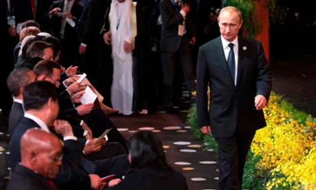 Vladimir Putin arrives at the Welcome to Country ceremony at the G20 summit as other world leaders sit.