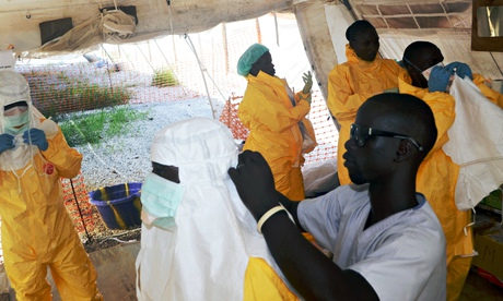 MSF doctors put on protective gear at an Ebola isolation ward in Guinea. Photograph: Cellou Binani/A