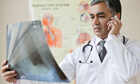 Doctor examining an x-ray and talking on a mobile phone