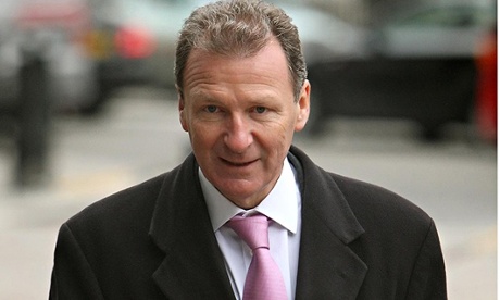 Lord O'Donnell walking outside in overcoat and holding green file